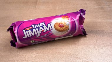 Yanında tatlı reçelli bisküvi paketleri. Sandviç bisküvileri veya ahşap arka planda kremalı bisküviler. 