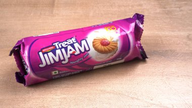 Yanında tatlı reçelli bisküvi paketleri. Sandviç bisküvileri veya ahşap arka planda kremalı bisküviler. 