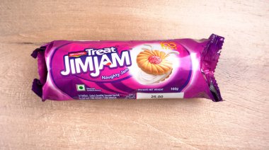 Yanında tatlı reçelli bisküvi paketleri. Sandviç bisküvileri veya ahşap arka planda kremalı bisküviler. 