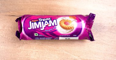 Yanında tatlı reçelli bisküvi paketleri. Sandviç bisküvileri veya ahşap arka planda kremalı bisküviler. 