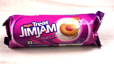 Yanında tatlı reçelli bisküvi paketleri. Sandviç bisküvileri veya ahşap arka planda kremalı bisküviler. 