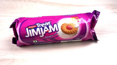 Yanında tatlı reçelli bisküvi paketleri. Sandviç bisküvileri veya ahşap arka planda kremalı bisküviler. 