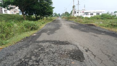 Yoldaki derin çukur. Hasarlı asfalt. Kötü yol. Yol onarımı