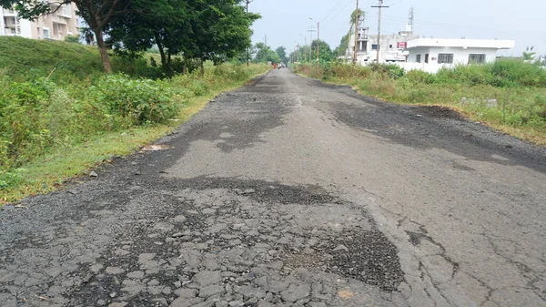 Yoldaki derin çukur. Hasarlı asfalt. Kötü yol. Yol onarımı