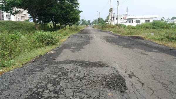 Yoldaki derin çukur. Hasarlı asfalt. Kötü yol. Yol onarımı