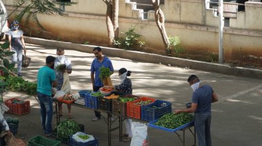 INDIA - 08 Mayıs 2020: Gündüz sebze pazarı ile sokakta duran kalabalık  