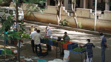 INDIA - 08 Mayıs 2020: Gündüz sebze pazarı ile sokakta duran kalabalık  