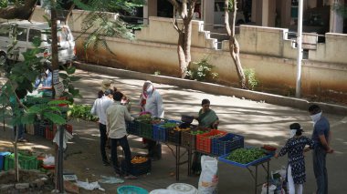 INDIA - 08 Mayıs 2020: Gündüz sebze pazarı ile sokakta duran kalabalık  