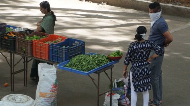 INDIA - 08 Mayıs 2020: Gündüz sebze pazarı ile sokakta duran kalabalık  