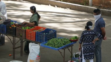 INDIA - 08 Mayıs 2020: Gündüz sebze pazarı ile sokakta duran kalabalık  