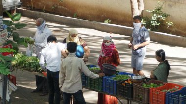 INDIA - 08 Mayıs 2020: Gündüz sebze pazarı ile sokakta duran kalabalık  