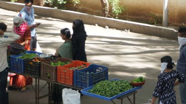 INDIA - 08 Mayıs 2020: Gündüz sebze pazarı ile sokakta duran kalabalık  