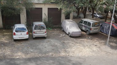 INDIA - 08 Mayıs 2020: Eski Hint şehrinin caddesinde gündüz vakti park etmiş arabalar 