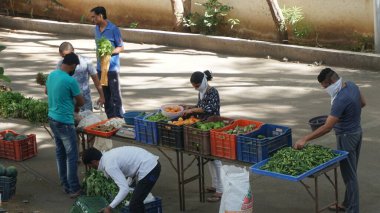 INDIA - 08 Mayıs 2020: Gündüz sebze pazarı ile sokakta duran kalabalık  