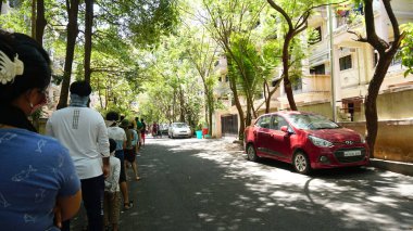 INDIA - 1 Mayıs 2020: Hintliler gündüz vakti arabaları ve yeşil ağaçlarıyla caddelerde hareket ediyorlar 