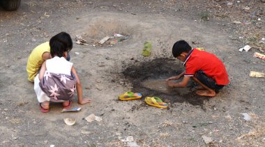 INDIA - 03th FEBRARY, 2020: Hintli çocuklar gündüz vakti su birikintisiyle oynuyorlar 
