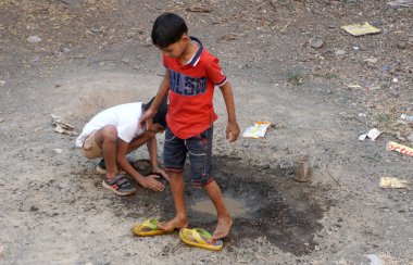INDIA - 03th FEBRARY, 2020: Hintli çocuklar gündüz vakti su birikintisiyle oynuyorlar 