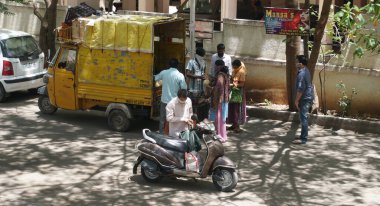 INDIA - 08 Mayıs 2020: Kalabalık gündüz vakti arabanın etrafında sebzelerle dikiliyor