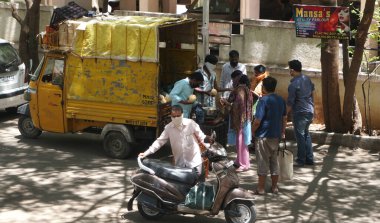 INDIA - 08 Mayıs 2020: Kalabalık gündüz vakti arabanın etrafında sebzelerle dikiliyor