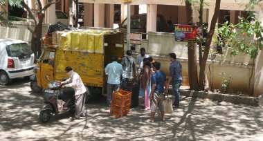 INDIA - 08 Mayıs 2020: Kalabalık gündüz vakti arabanın etrafında sebzelerle dikiliyor
