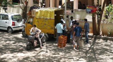 INDIA - 08 Mayıs 2020: Kalabalık gündüz vakti arabanın etrafında sebzelerle dikiliyor