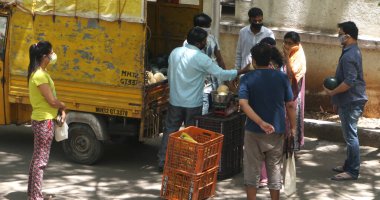 INDIA - 08 Mayıs 2020: Kalabalık gündüz vakti arabanın etrafında sebzelerle dikiliyor