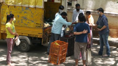 INDIA - 08 Mayıs 2020: Kalabalık gündüz vakti arabanın etrafında sebzelerle dikiliyor