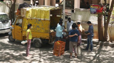 INDIA - 08 Mayıs 2020: Kalabalık gündüz vakti arabanın etrafında sebzelerle dikiliyor