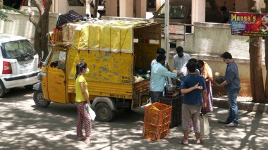INDIA - 08 Mayıs 2020: Kalabalık gündüz vakti arabanın etrafında sebzelerle dikiliyor