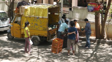 INDIA - 08 Mayıs 2020: Kalabalık gündüz vakti arabanın etrafında sebzelerle dikiliyor