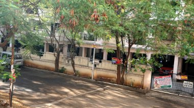 INDIA - 1 Mayıs 2020: Gündüz vakti arabalı ve yeşil ağaçlı Hindistan Caddesi 