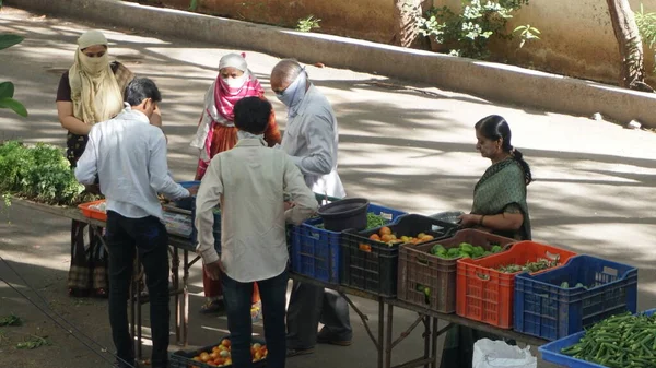 INDIA - 08 Mayıs 2020: Gündüz sebze pazarı ile sokakta duran kalabalık  