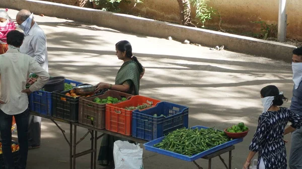 INDIA - 08 Mayıs 2020: Gündüz sebze pazarı ile sokakta duran kalabalık  