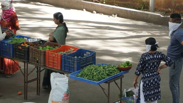 INDIA - 08 Mayıs 2020: Gündüz sebze pazarı ile sokakta duran kalabalık  