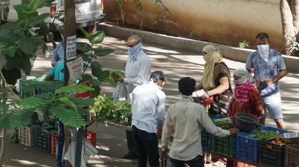 INDIA - 08 Mayıs 2020: Gündüz sebze pazarı ile sokakta duran kalabalık  