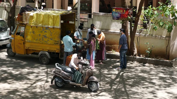 INDIA - 08 Mayıs 2020: Kalabalık gündüz vakti arabanın etrafında sebzelerle dikiliyor