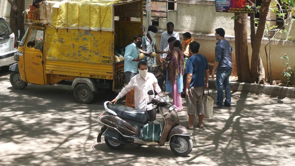 INDIA - 08 Mayıs 2020: Kalabalık gündüz vakti arabanın etrafında sebzelerle dikiliyor