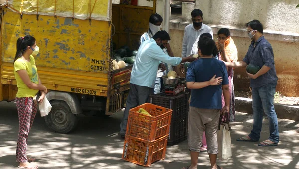 INDIA - 08 Mayıs 2020: Kalabalık gündüz vakti arabanın etrafında sebzelerle dikiliyor