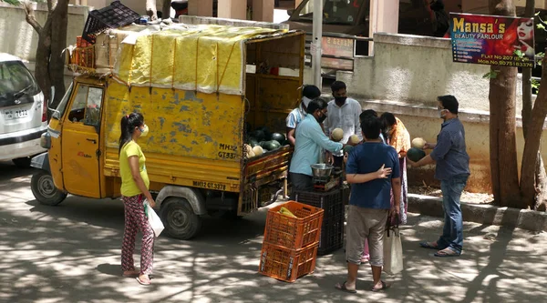 INDIA - 08 Mayıs 2020: Kalabalık gündüz vakti arabanın etrafında sebzelerle dikiliyor