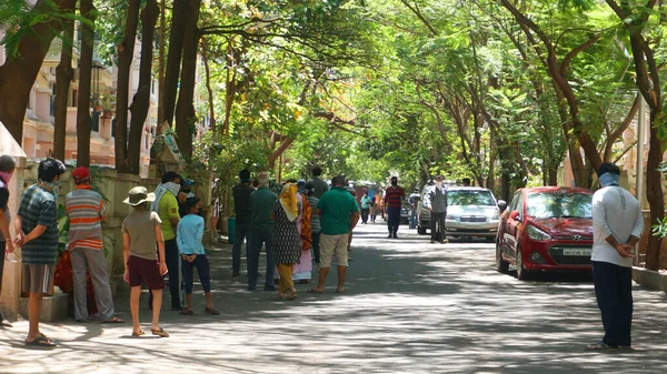 India 2020年5月8日 緑の木々の影に駐車中の車で古い通りを歩く群衆 — ストック写真