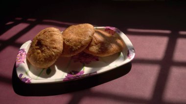 Taze çörekler ve yeşil biberlerle kaplanmış bir tabak.