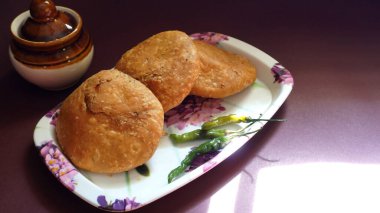 Taze çörekler ve yeşil biberlerle kaplanmış bir tabak.