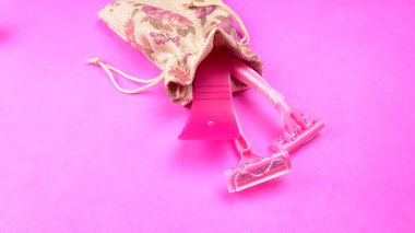 Pembe arka planda kadın pembe tıraş makineleri