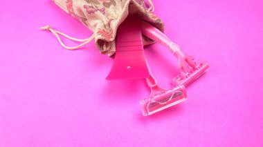 Pembe arka planda kadın pembe tıraş makineleri