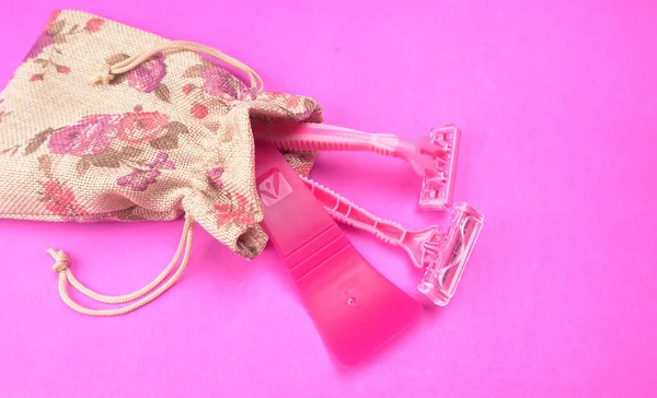 Pembe arka planda kadın pembe tıraş makineleri