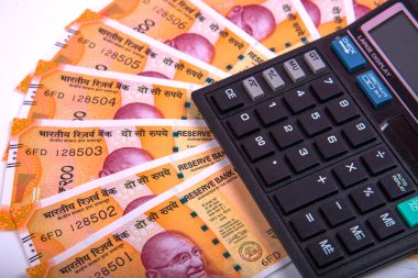 Beyaz arka planda Hint rupi faturaları ve hesap makinesi. Vergi ödeme konsepti veya yatırım çözümleri. Mali planlama ya da muhasebeci evrakları