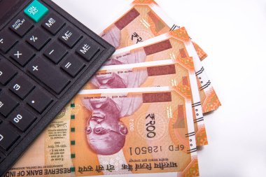 Beyaz arka planda Hint rupi faturaları ve hesap makinesi. Vergi ödeme konsepti veya yatırım çözümleri. Mali planlama ya da muhasebeci evrakları