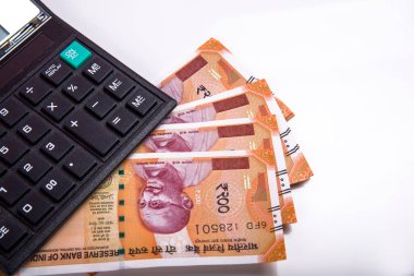 Beyaz arka planda Hint rupi faturaları ve hesap makinesi. Vergi ödeme konsepti veya yatırım çözümleri. Mali planlama ya da muhasebeci evrakları