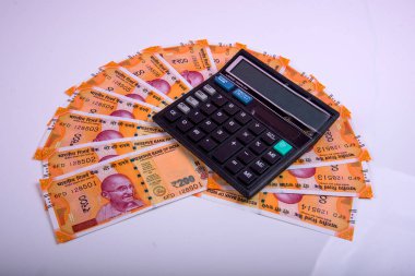 Beyaz arka planda Hint rupi faturaları ve hesap makinesi. Vergi ödeme konsepti veya yatırım çözümleri. Mali planlama ya da muhasebeci evrakları