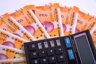 Beyaz arka planda Hint rupi faturaları ve hesap makinesi. Vergi ödeme konsepti veya yatırım çözümleri. Mali planlama ya da muhasebeci evrakları